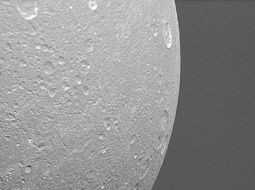Диона на фоне колец Сатурна